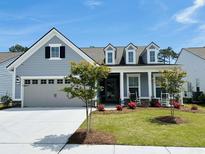 Charming home with a well-manicured lawn, inviting front porch, and a two-car garage at 7246 Sarteano Dr., Myrtle Beach, SC 29572