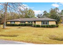Charming one-story brick home with mature landscaping and a well-maintained front yard at 74 Brandy Ln., Georgetown, SC 29440