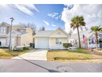 Cute yellow house with white picket fence and small patio at 121 Whitehaven Ct., Myrtle Beach, SC 29577