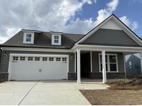 Charming home featuring a two-car garage, dormer windows, and covered entryway with brick base columns at 1240 Winding Creek Way, Myrtle Beach, SC 29588