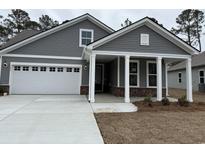 Charming home with gray siding, white trim, brick accents, and a welcoming front porch at 1255 Winding Creek Way, Myrtle Beach, SC 29588