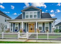 Charming two-story home with a covered porch, white picket fence and nicely landscaped front yard at 2023 Singing Palm Loop, Little River, SC 29566