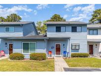 Charming two-story townhome with light blue siding, a well-manicured lawn, and an inviting front entrance at 775 Plantation Dr. # 59, Little River, SC 29566