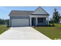 Charming single-story home with blue siding, white trim, and a well-manicured lawn at 210 Carver Willow Dr., Loris, SC 29569