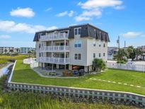 Multi-story beach house with multiple balconies, a pool, and outdoor entertaining area at 300 63Rd Ave. N # 306-C, North Myrtle Beach, SC 29582