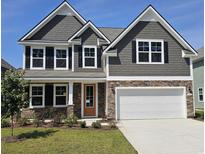 Charming two-story home featuring stone accents, gray siding, a two-car garage, and a well-manicured lawn at 562 Haven View Way, Murrells Inlet, SC 29576