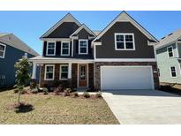 Charming two-story home with stone accents, a well-manicured lawn, and a spacious two-car garage at 562 Haven View Way, Murrells Inlet, SC 29576