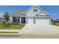 Charming home featuring a two-car garage, manicured lawn, and inviting front porch at 771 St. Vincent Loop, Little River, SC 29566