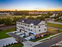 Beautiful three-story townhomes boast brick accents, covered entries, and ample parking at sunset at 8411 Flamingo Ct. # 7, Myrtle Beach, SC 29572