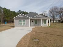 Charming single-story home with gray siding, white trim, a covered front porch, and a concrete driveway at 941 Hickman Rd., Tabor City, NC 28463