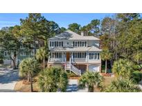 Two-story home with gray metal roof, brick accents, and a landscaped yard at 112 Cockle Shell Ct., Pawleys Island, SC 29585