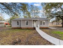 Charming single-story home featuring gray siding, white trim, and a welcoming front porch at 447 Bragdon Ave., Georgetown, SC 29440