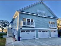 Exterior front of waterfront home featuring a three-car garage and multiple balconies at 100 Comfort Ln., Pawleys Island, SC 29585