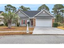 Charming home featuring a two car garage, well-maintained landscaping, and a beautiful palm tree in the front yard at 158 Regency Dr., Conway, SC 29526