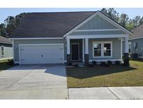 Charming single-story home features a garage, manicured lawn and inviting front porch at 1916 Seachase Way, North Myrtle Beach, SC 29582