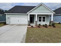 Charming home with a well-maintained lawn, a two-car garage, and stone-accented porch columns at 1916 Seachase Way, North Myrtle Beach, SC 29582