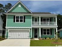 Charming two-story home features a welcoming front porch, light green siding, and attached two car garage at 535 Slaty Dr., Myrtle Beach, SC 29588