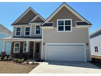 Charming two-story home with a stone facade and a two-car garage, nestled under a clear blue sky at 550 Haven View Way, Murrells Inlet, SC 29576