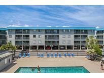 Aerial view of a three-story building with pool and oceanfront location at 6001 N Ocean Blvd. # 243, North Myrtle Beach, SC 29582