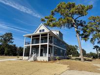 Two-story home with gray siding, white trim, and a wrap-around porch at 825 Commanders Island Dr., Georgetown, SC 29440