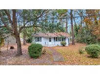 White house with black shutters, surrounded by trees and a walkway at 1105 Hemingway St., Myrtle Beach, SC 29577