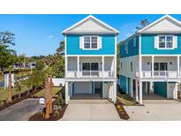 Charming two-story coastal home with a blue exterior, white trim, and a convenient drive-under garage at 2302 Seaseeker Ln., Myrtle Beach, SC 29577