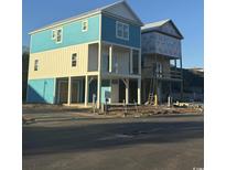 View of new blue and white two-story construction with pilings on a sunny day near the road at 2302 Seaseeker Ln., Myrtle Beach, SC 29579