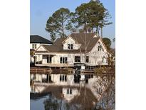 Waterfront home with large windows reflected in the water offers scenic views at 1020 Clamour Ct., Conway, SC 29526