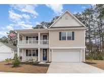 Two-story house with beige siding, a white door, and a two-car garage at 141 Ranch Haven Dr., Murrells Inlet, SC 29576