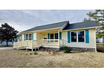 Ranch style home with light yellow siding, teal shutters, and a ramp at 9404 Chicory Ln., Murrells Inlet, SC 29576