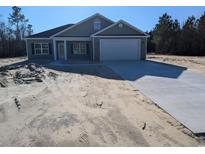 Newly constructed home with gray siding, attached garage, and a spacious driveway at Tbd 18 Casey Dr., Nichols, SC 29581