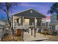 Elevated home with gray siding, large deck, and ample parking at 6001 - 1450 S Kings Hwy., Myrtle Beach, SC 29575