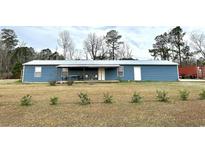 Charming single-story home featuring a metal roof, covered porch, and a spacious front yard at 445 W Willow Pond Rd., Johnsonville, SC 29555
