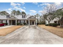 Two-story townhome with gray metal roof, brick facade, and covered porch at 448 Colonial Trace Dr. # 448, Longs, SC 29568