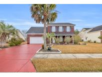 Brick two-story house with a red driveway and palm trees at 5096 Capulet Circle, Myrtle Beach, SC 29588
