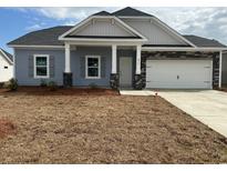 Charming single-story home with gray siding, stone accents, and a two-car garage at 576 Honeyhill Loop, Conway, SC 29526