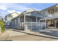 Charming single-story beach house with a spacious covered porch and beachy blue siding at 6001 South Kings Hwy., Myrtle Beach, SC 29575