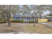 Brick ranch home with blue shutters, a white porch, and a fenced yard at 723 Brook Ln., Conway, SC 29526