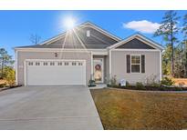 Charming one-story home with a two-car garage and landscaped lawn at 747 Coquina Bay Dr., Conway, SC 29526