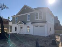 Two story home with light green and white siding, front door, and attached one car garage at 931 Edge Dr., North Myrtle Beach, SC 29582