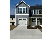 Charming two-story home with a white garage door, gray siding, and a welcoming yellow front door at 290 Myrtle Meadows Dr # 505F, Conway, SC 29526