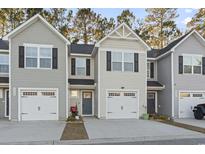 Three-unit townhome building with two-car garages and neutral siding at 608 Montenegro Way # D, Myrtle Beach, SC 29579
