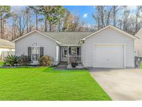 Gray house with a 1-car garage and nicely landscaped front yard at 9692 Conifer Ln., Murrells Inlet, SC 29576