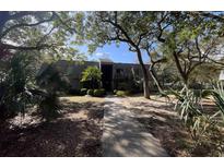 Inviting condo building with a landscaped walkway, surrounded by lush greenery at 178 Salt Marsh Circle # 30-E, Pawleys Island, SC 29585