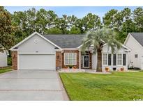 Brick and white charming house with a large driveway and palm tree at 182 Glenwood Dr., Conway, SC 29526