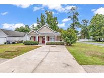 Beige house with red door, driveway, and green lawn at 1900 Shell Ct., Myrtle Beach, SC 29575