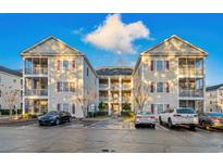 Inviting multi-story condo building showcases classic design with red shutters and ample parking space at 2060 Cross Gate Blvd. # 204, Surfside Beach, SC 29575