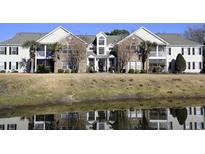 Beautiful two-story home with brick facade, lots of windows, and reflected in a pond at 4657 Fringetree Dr. # C, Murrells Inlet, SC 29576