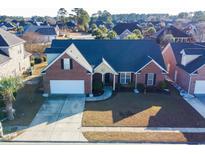 Charming brick home featuring a two-car garage and well-manicured lawn, complemented by mature trees in a desirable neighborhood at 582 Summerhill Dr., Myrtle Beach, SC 29579