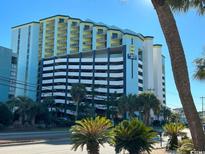 Oceanfront resort building with parking and palm trees at 6804 N Ocean Blvd. # 1527, Myrtle Beach, SC 29572